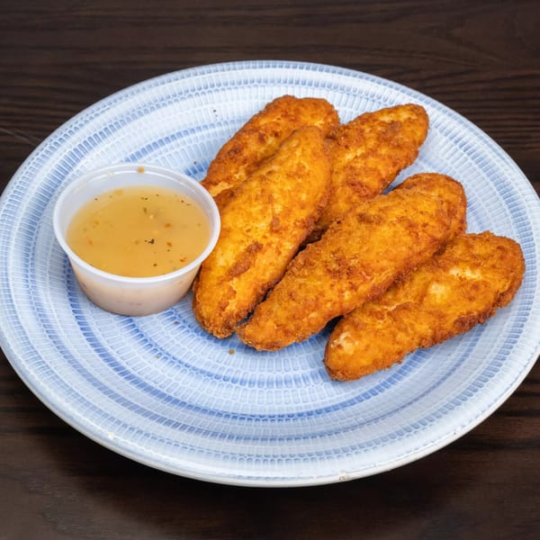 Five golden-brown chicken fingers and a small cup of dipping sauce on a blue and white plate.