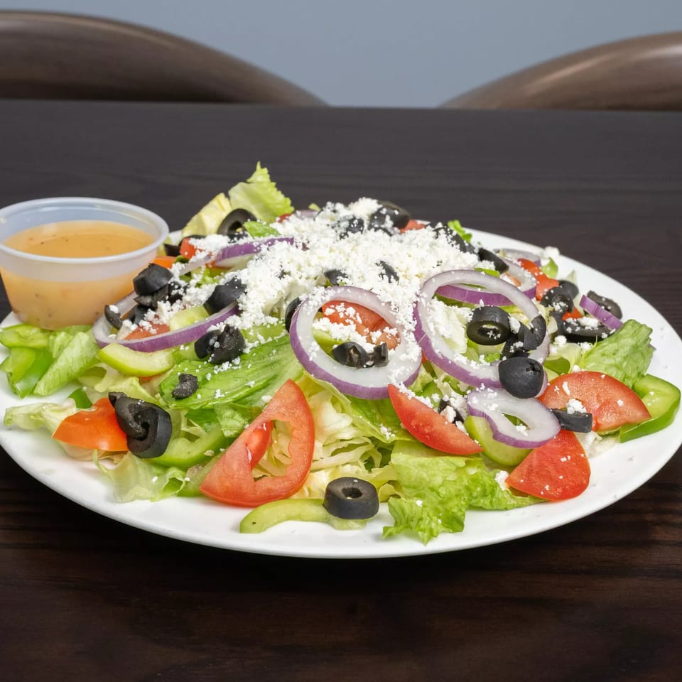 Garlex Pizza & Ribs' Italian salad with lettuce, tomatoes, onions, olives, and feta cheese.